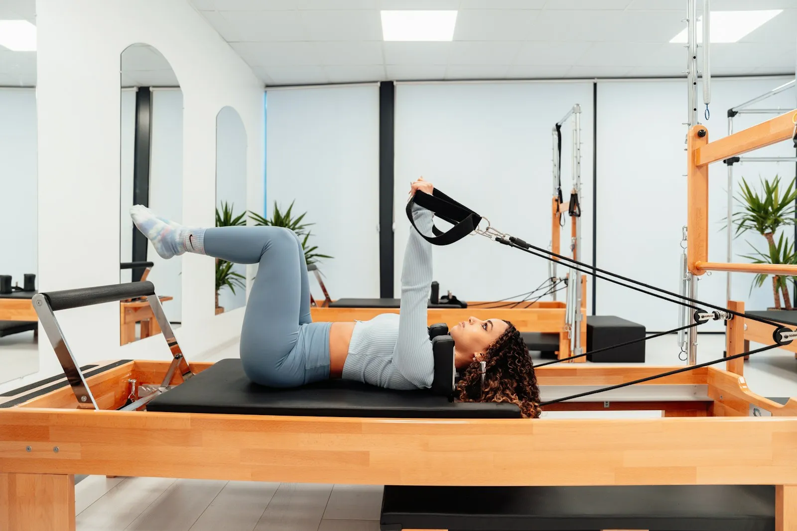 A woman on a reformer with her legs in the straps